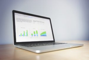 an image of a laptop displaying a variety of graphs and charts